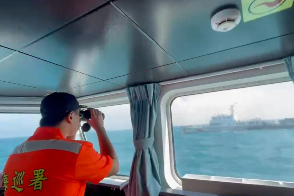 Ein Mitglied der taiwanischen Küstenwache beobachtet ein Boot der chinesischen Küstenwache, das an der Küste der Matsu-Inseln in Taiwan vorbeifährt.