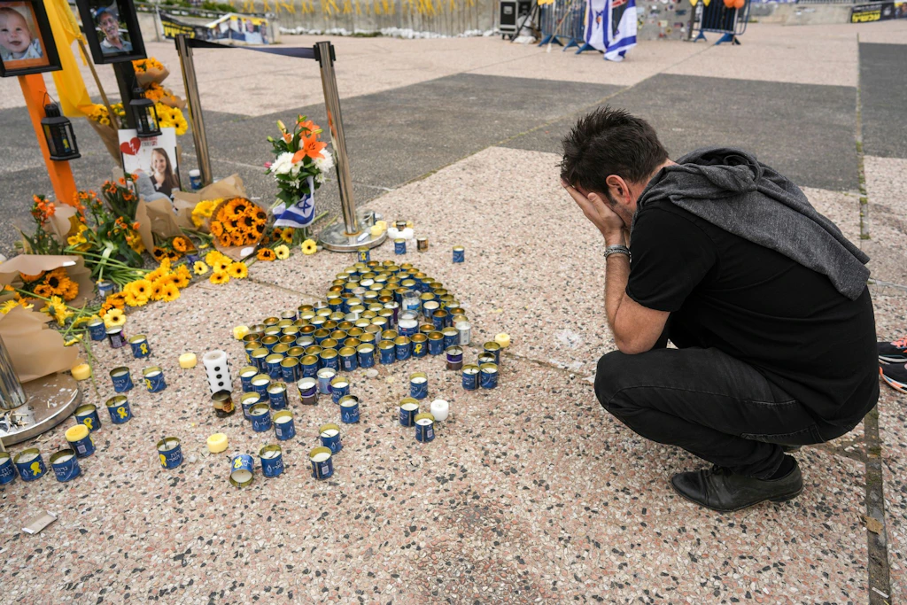 Ein Mann betet am Geiselplatz in Tel Aviv an einer Gedenkstätte für Schiri Bibas, ihre Söhne Ariel und Kfir sowie Oded Lifschitz.