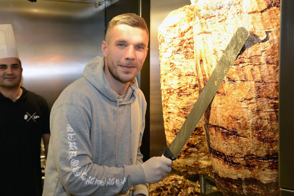 Der Chef liegt hier selbst Hand an. Lukas Podolski bei der Eröffnung eines Döner-Ladens in Köln.