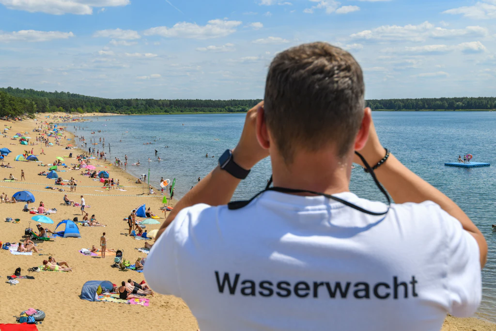 Ein Rettungsschwimmer beobachtet die Badegäste am Helenesee in Brandenburg.