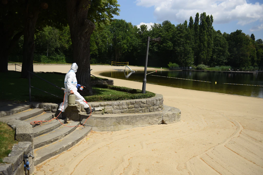 Im Vollschutzanzug: Luca Meihack brennt die giftigen Härchen auch am Sandstrand weg.