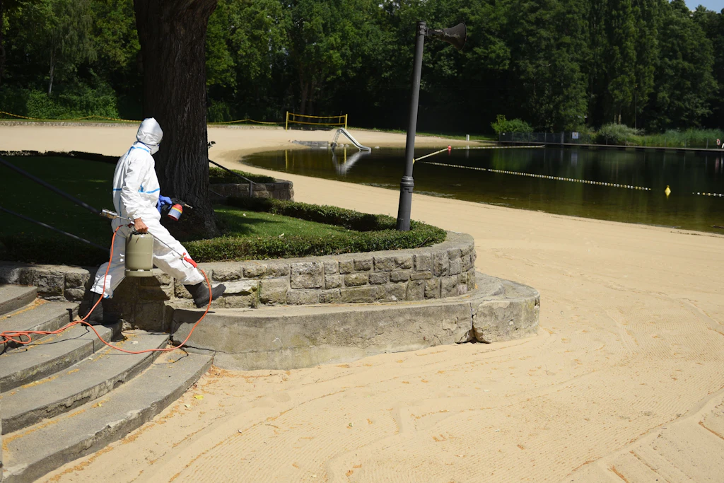 Im Vollschutzanzug: Luca Meihack brennt die giftigen Härchen auch am Sandstrand weg.