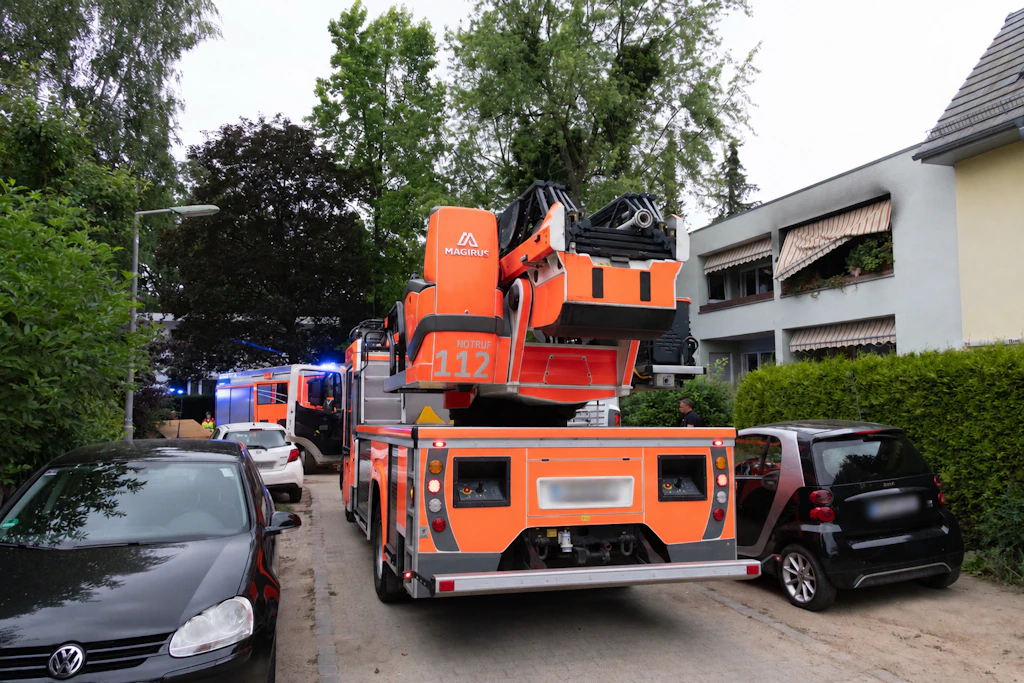 Die Einsatzfahrzeuge der Feuerwehr vor dem betroffenen Wohnhaus in Lichterfelde, in dem der Brand ausgebrochen war
