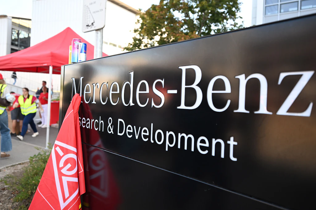 Am Eingang Tor 7 zum Mercedes-Benz-Werk steht eine Fahne der Gewerkschaft IG Metall bereit. Mitarbeiter versammeln sich zu einer großen Demonstration gegen den verschärften Sparkurs.