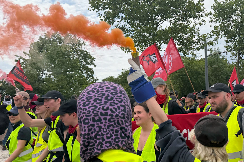 Demonstranten gegen den AfD-Bundesparteitag entzünden Rauchfackeln.