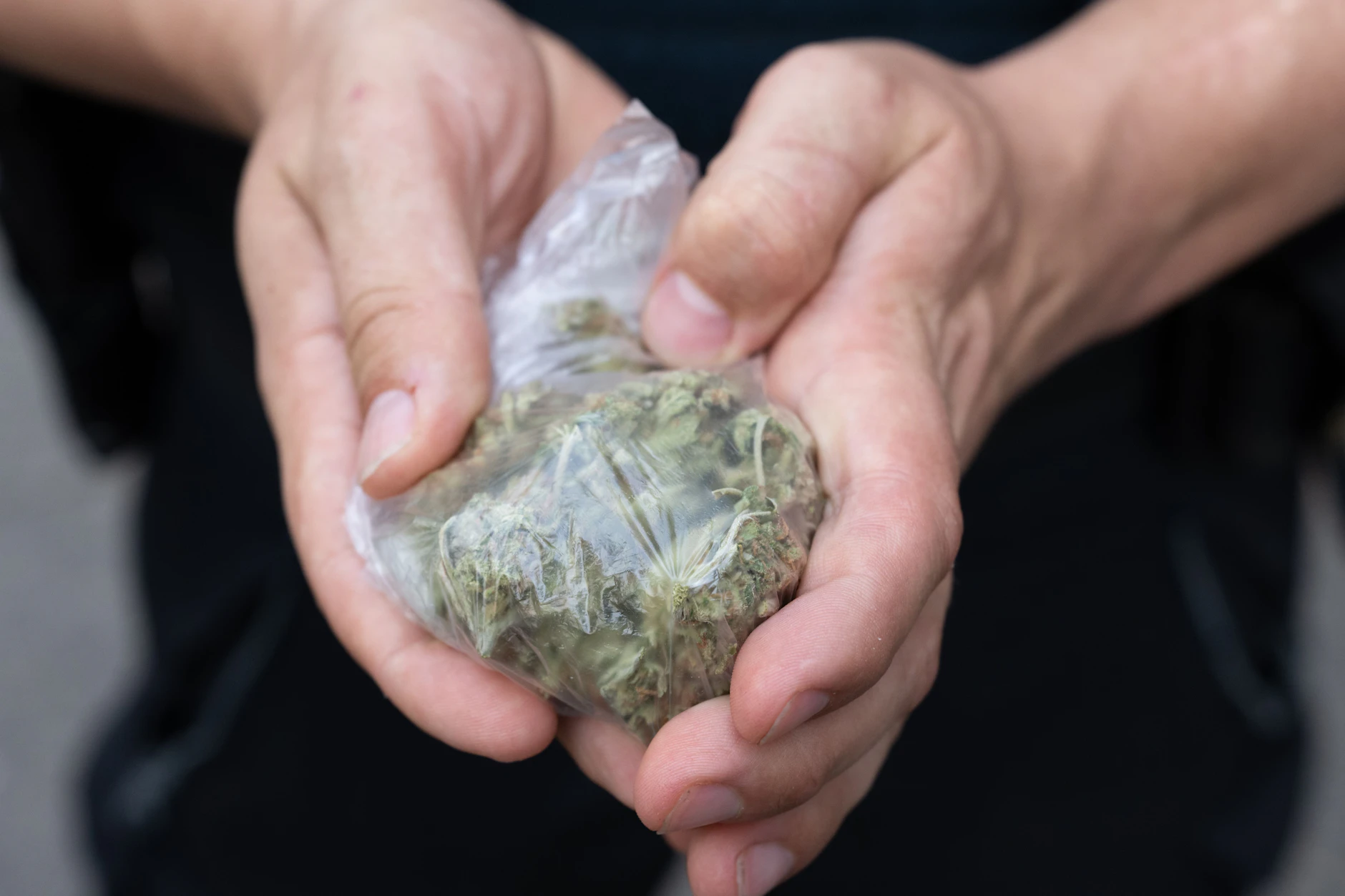 Ein Polizist hält sichergestelltes Cannabis in Händen (Symbolfoto).