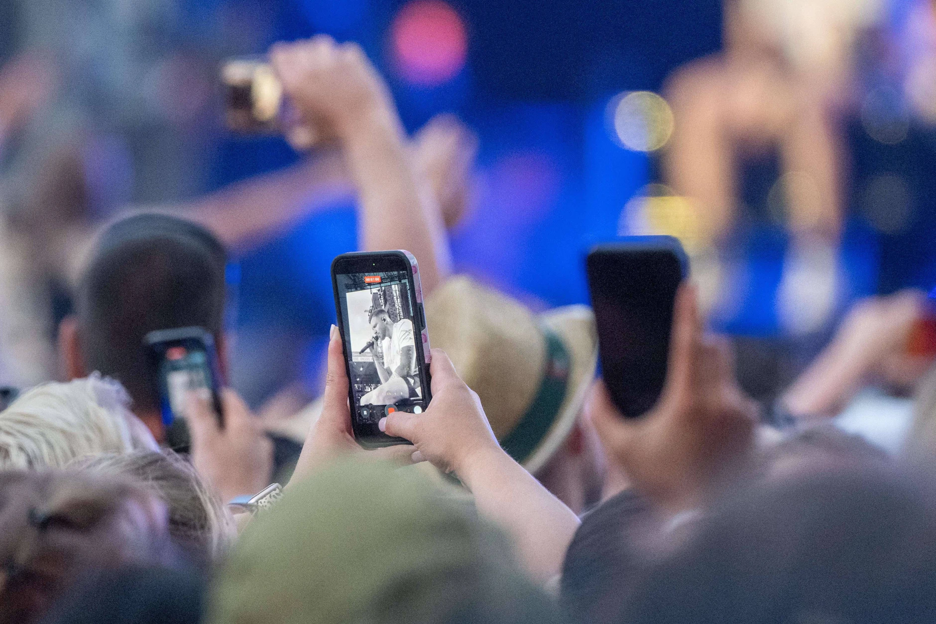 Menschen filmen bei Konzerten mit ihren Handys, um Erinnerungen festzuhalten, sie in sozialen Medien zu teilen und zu dokumentieren, dass sie live dabei waren.