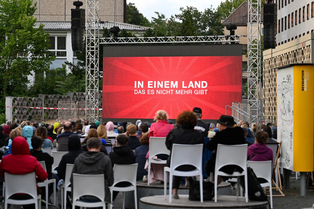 Etwa 350 Zuschauer verfolgen im Campus-Kino im Innenhof der ehemaligen Stasi-Zentrale die Aufführung des Films <a href="https://www.berliner-kurier.de/panorama/mann-findet-millionen-betrag-in-der-mauer-jetzt-hat-er-ein-riesiges-problem-li.10213738">„In einem Land, das es nicht mehr gibt“</a> von Regisseurin Aelrun Goette.