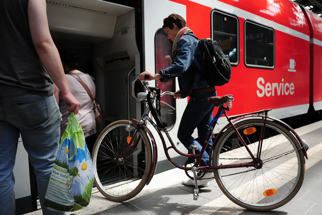 Eine junge Frau schiebt ihr Fahrrad in einen Regionalexpresszug von DB Regio. Auch für Fahrradtickets ist im Verkehrsverbund Berlin-Brandenburg 2027 mehr zu bezahlen.