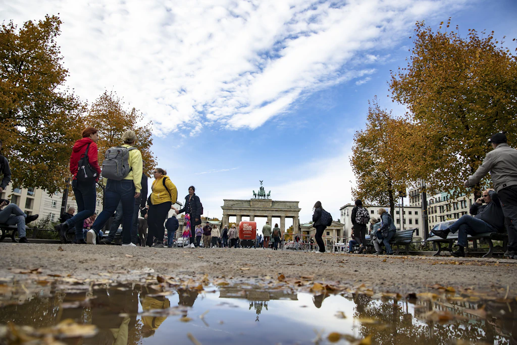 Menschen laufen vor dem Brandenburger Tor in Berlin. Jeglicher Handel dort wird geahndet.