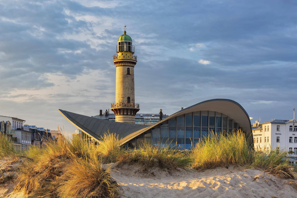 Leuchtturm, Restaurant Teepott und Dünen mit Strandhafer in Warnemünde. Der Herbst ist traditionell eine gute Zeit für eine entspannte Ostseereise.
