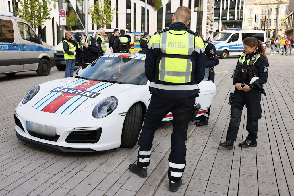 Polizeibeamte kontrollieren einen Porsche.