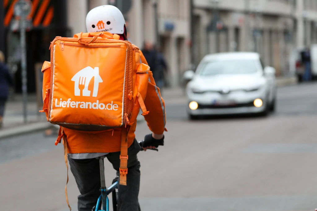 Heiß und fettig: Ein Radfahrer liefert für Lieferando Essen aus. Eine Studie untersucht die Unfallbelastung solcher Delivery Rider.