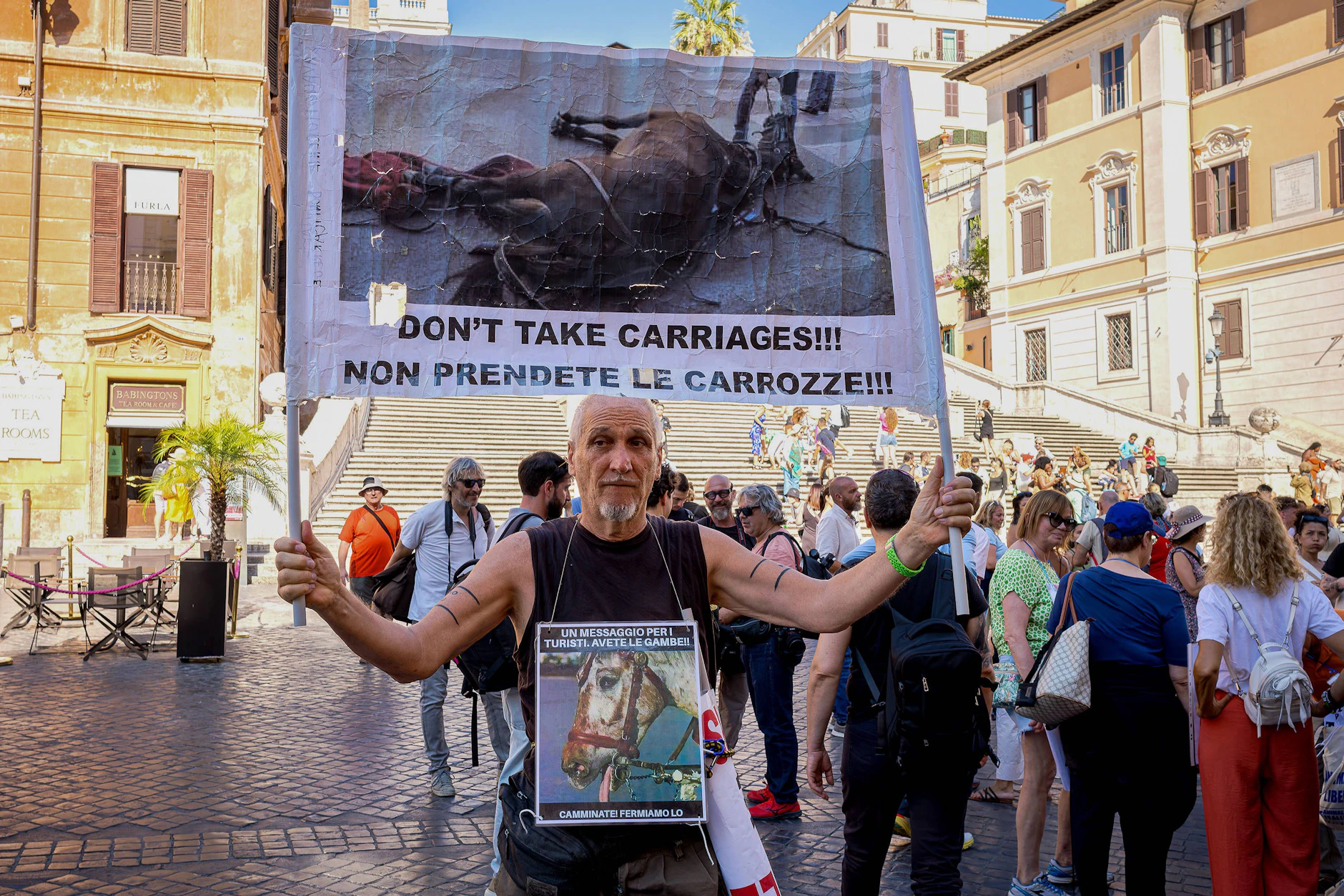 Ein Demonstrant gegen Pferdekutschen in Rom im Jahr 2024. Er ruft Touristen auf: Nehmt keine Kutschen!