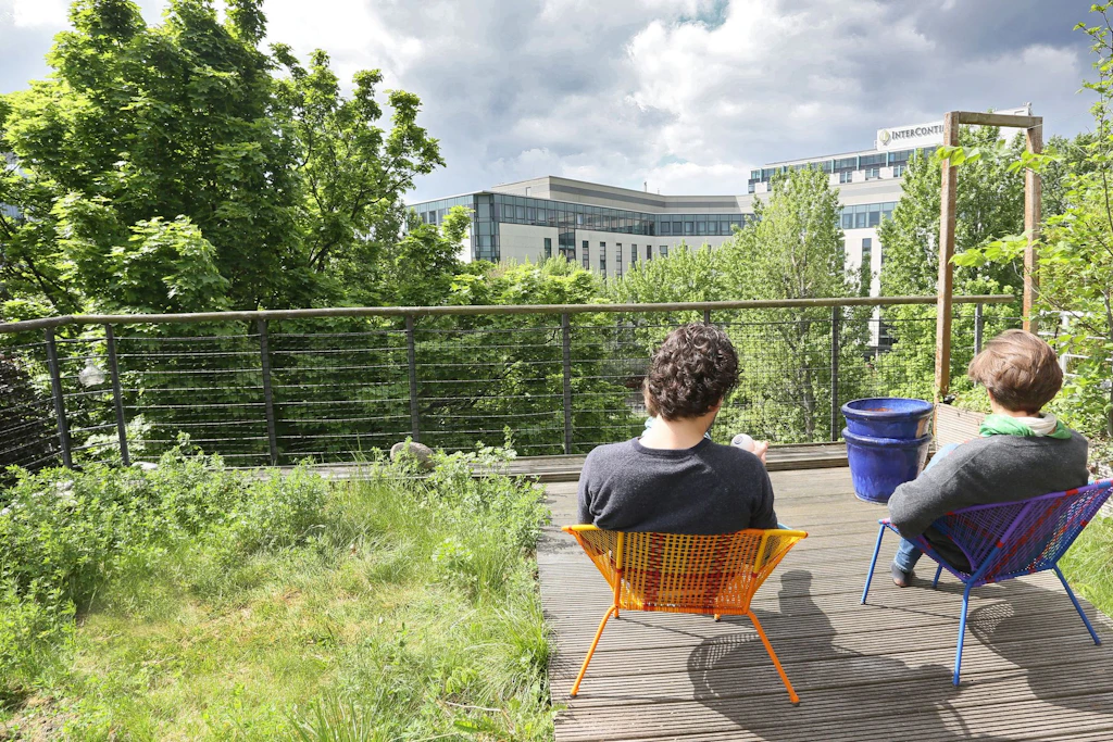 Auf dem begrünten Dach eines Öko-Hauses des Architekten Frei Otto sitzt ein Paar in der Berliner Innenstadt.