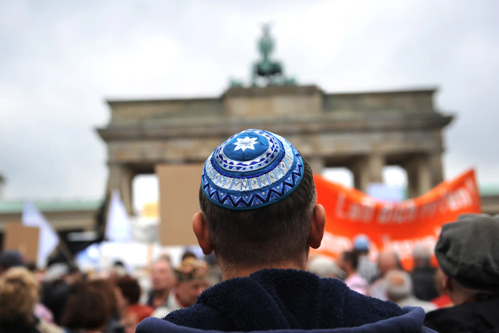 Teilnehmer der Kundgebung „Steh auf! Nie wieder Judenhass!“ des Zentralrats der Juden in Deutschland stehen vor dem Brandenburger Tor in Berlin (Archivbild).