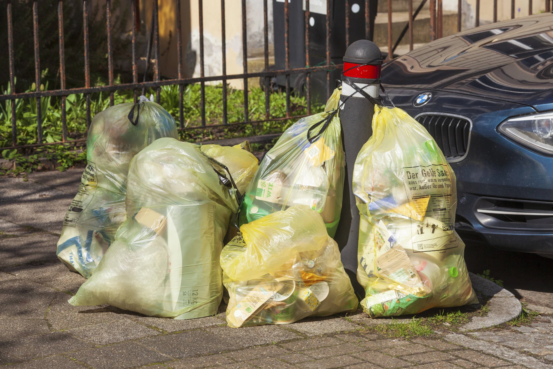 Gelbe Säcke mit Verpackungsmüll am Straßenrand: Ab 2027 wird nicht recyceltes Plastik über die neue Steuer teurer.