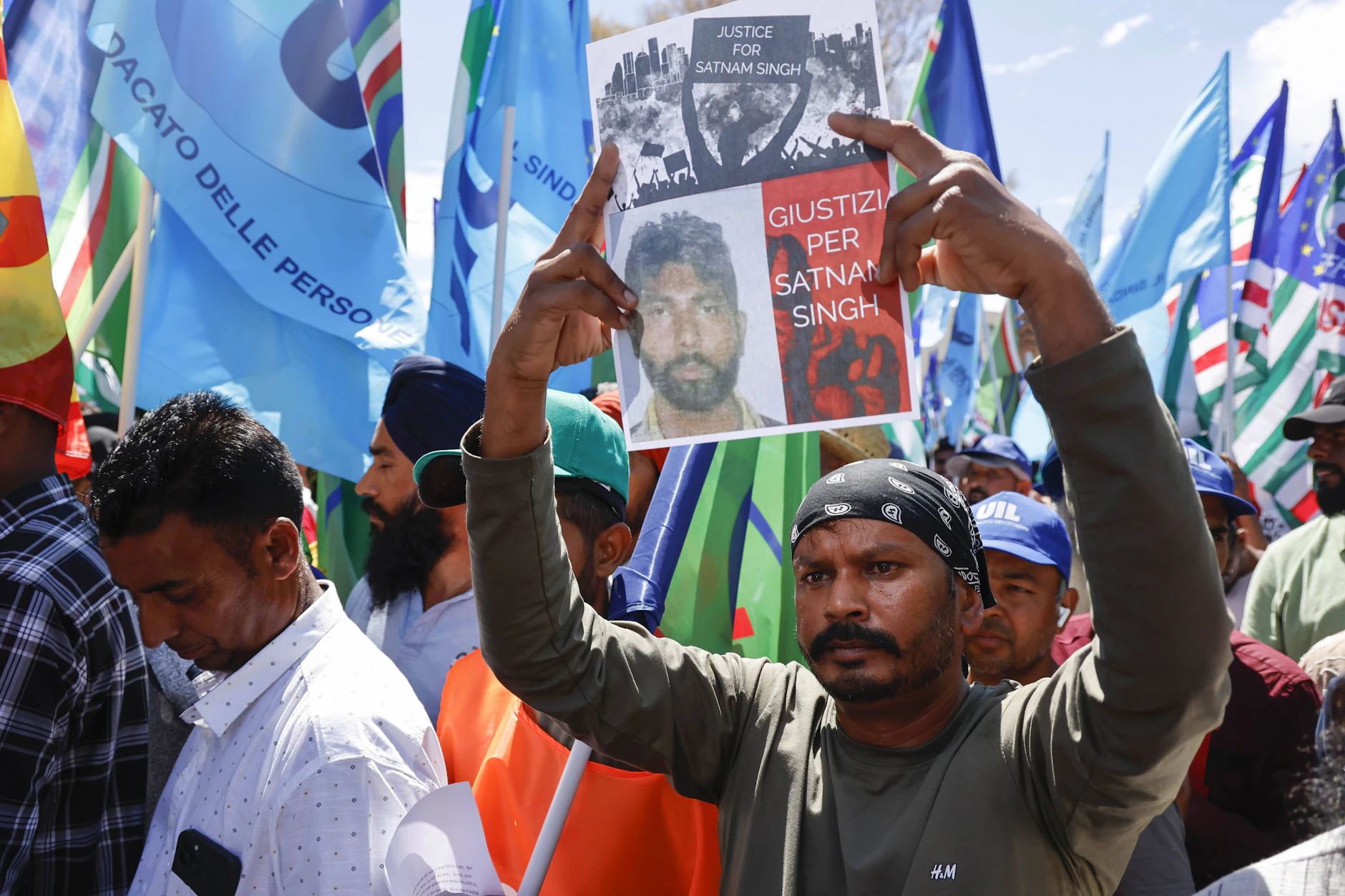 Protest nach dem Tod des Erntehelfers Satnam Singh in Latina in Italien, ein Demonstrant zeigt ein Foto des jungen Inders.