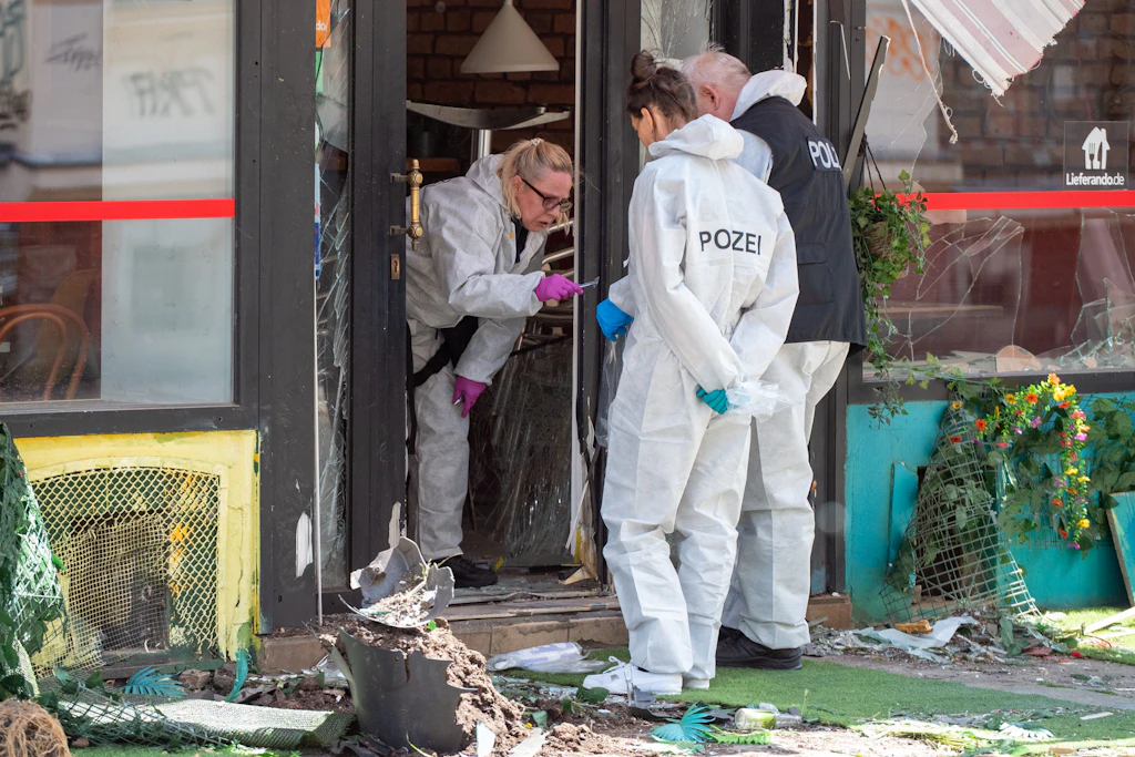 Trümmer vor der Pizzeria „La Migliore“ in Leipzig: Eine Explosion hat den Eingangsbereich schwer beschädigt. Die Polizei sicherte am Tatort zahlreiche Spuren.