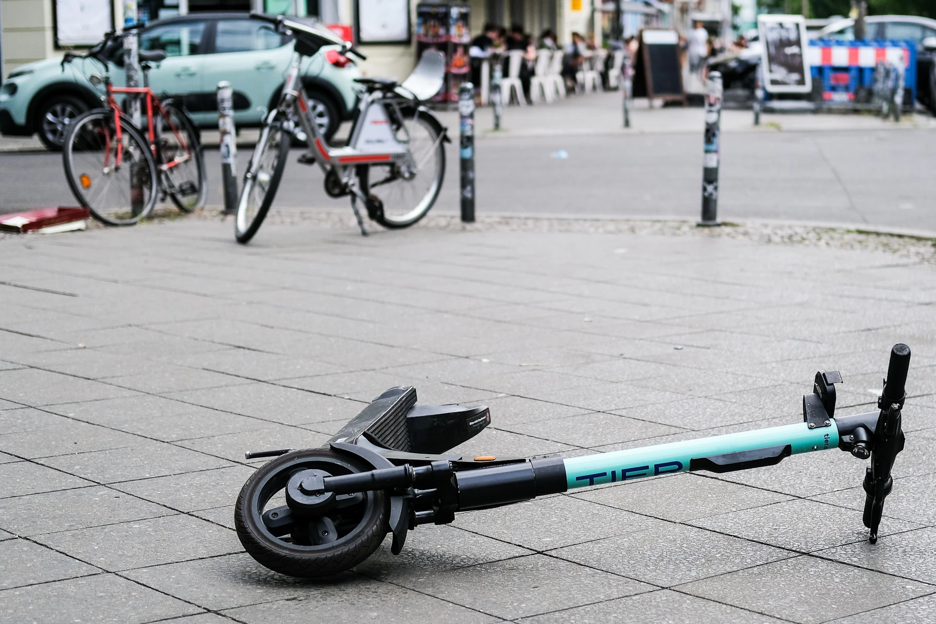 Ein E-Scooter liegt umgekippt mitten auf einem Gehweg.