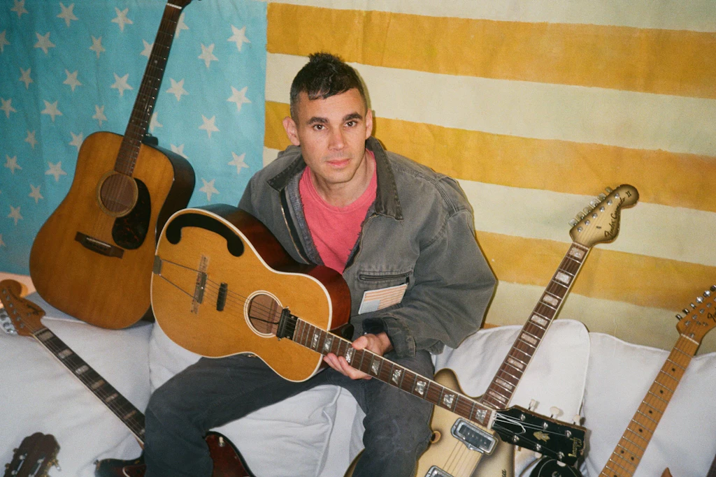 „Heute verstehe ich sehr viel klarer als mit 22, was es bedeutet, Künstler zu sein“: Rostam vor einer modifizierten USA-Flagge