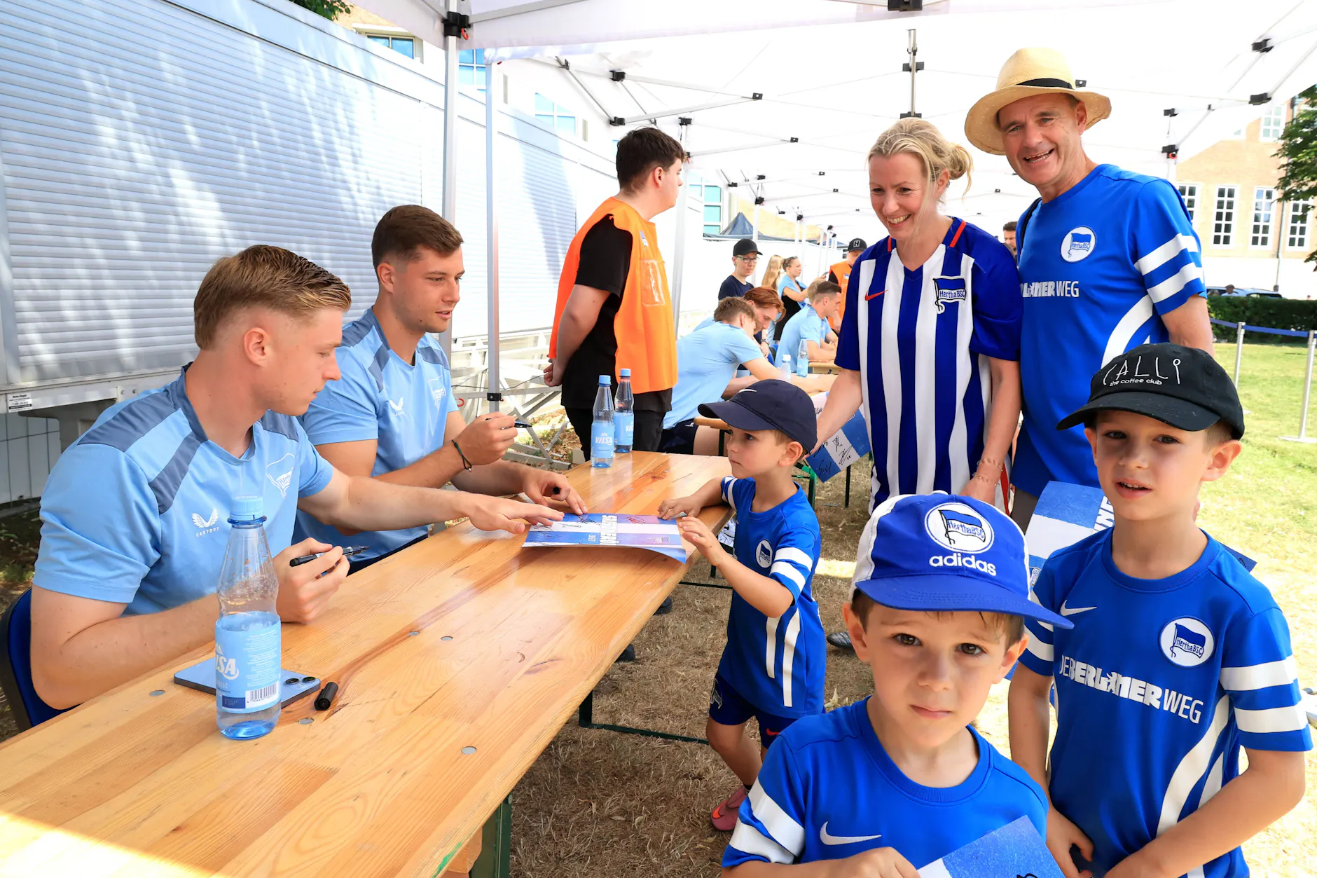Hertha-Torwart Tjark Ernst und Verteidiger Julian Eitschberger unterschrieben im Akkord Autogrammkarten.