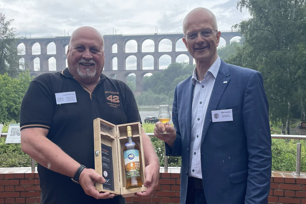 Thomas Michalski von der Dresdner Whisky-Manufaktur präsentiert mit Netzschkaus Bürgermeister Mike Purfürst den Jubiläumstropfen