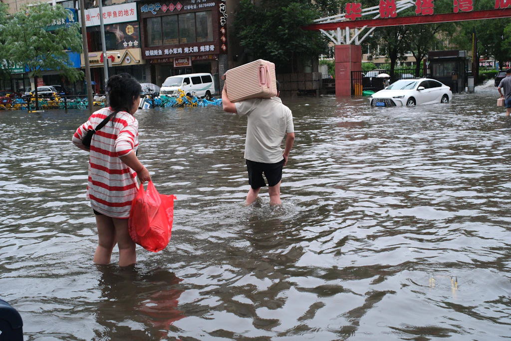 Bewohner waten in Shenyang in der nordostchinesischen Provinz Liaoning durch überflutete Straßen.