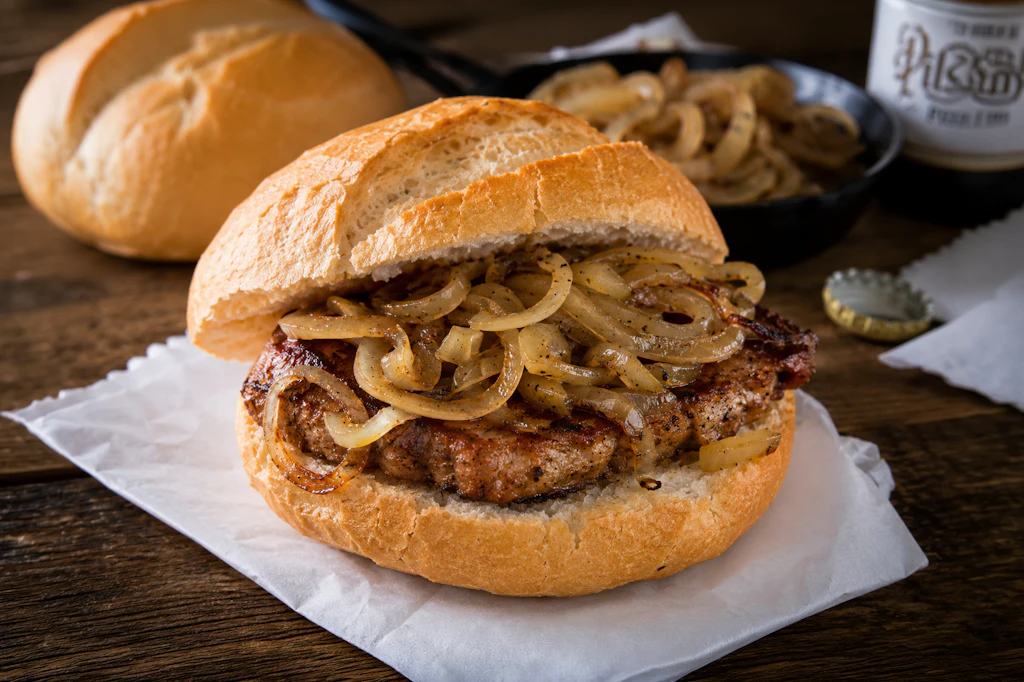 Da läuft Grill-Fans das Wasser im Mund zusammen: Nackensteak mit geschorten Zwiebeln im Brötchen sind ein echtes Highlight beim Grillabend!