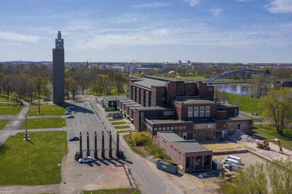 Die Stadthalle Magdeburg, links der Albin-Müller-Turm, davor das Pferdetor – als Parkplatzbegrenzung.