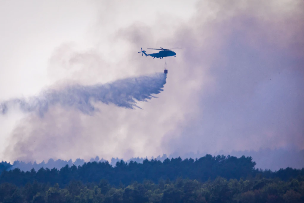Ein Bundeswehr-Hubschrauber CH-53 wirft aus dem 5000-Liter-Tank Löschwasser über dem Waldbrand im Müritz-Nationalpark ab.