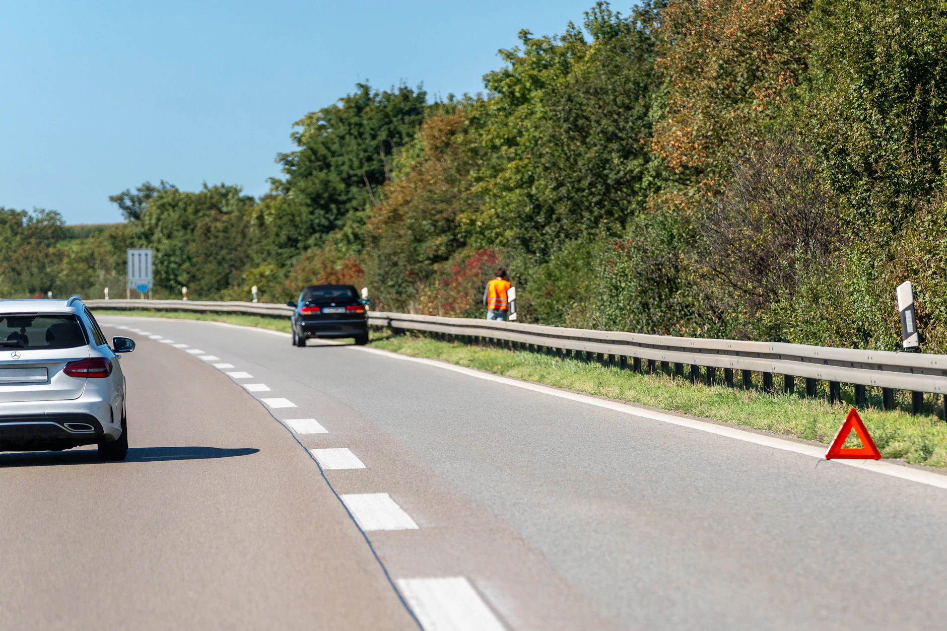 Bei einer Panne auf der Autobahn hinter der Leitplanke bleiben, auch beim Aufstellen des Warndreiecks.