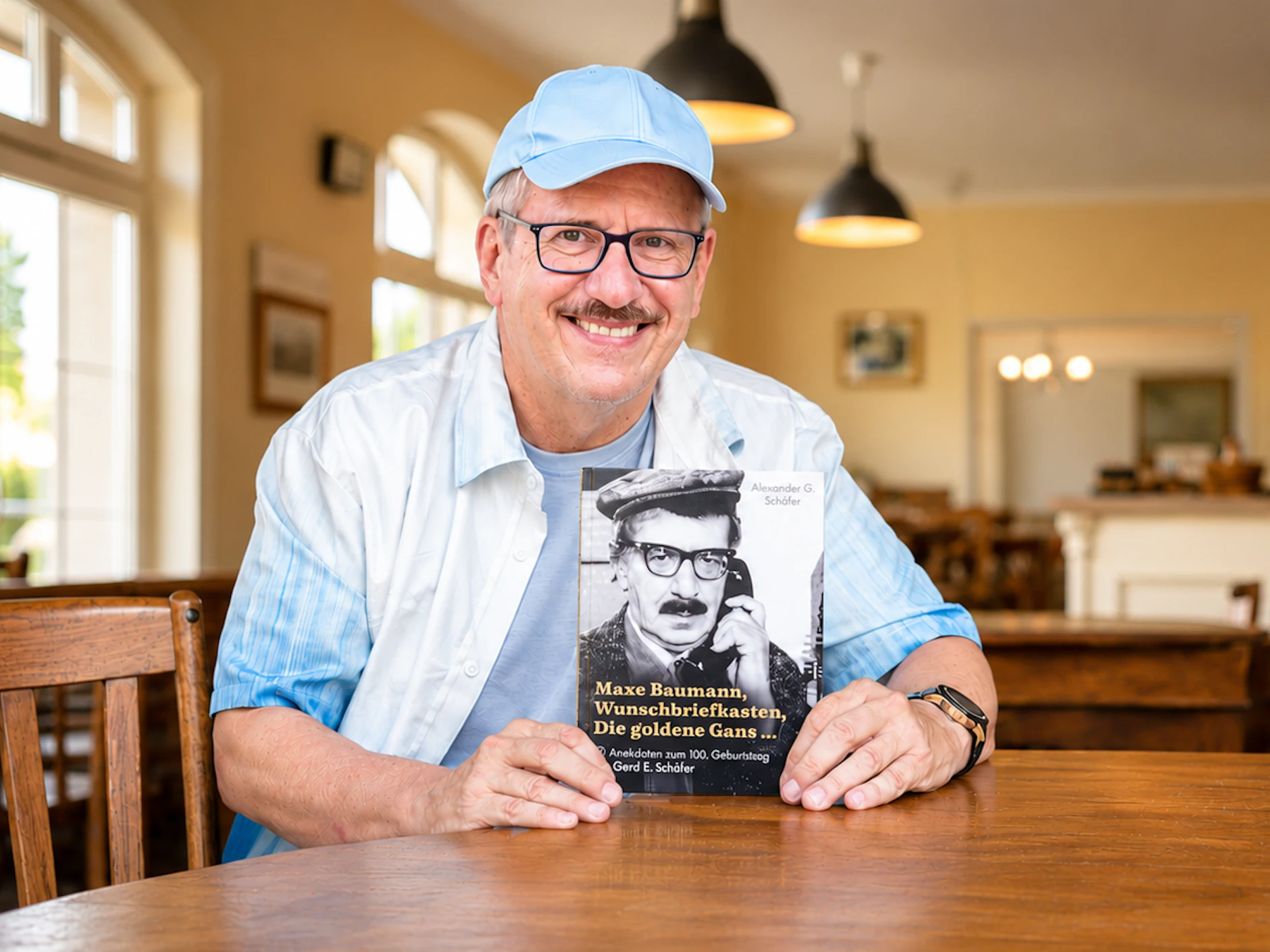 Die Ähnlichkeit ist verblüffend: Alexander G. Schäfer mit dem Buch über seinen Vater Gerd E. Schäfer, der vor fast 50 Jahren das erste Mal die Rolle von Maxe Baumann spielte.