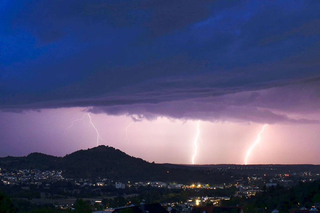 Blitze zucken bei einem Sommergewitter in der Nacht in Eningen unter Achalm. Baden-Württemberg.