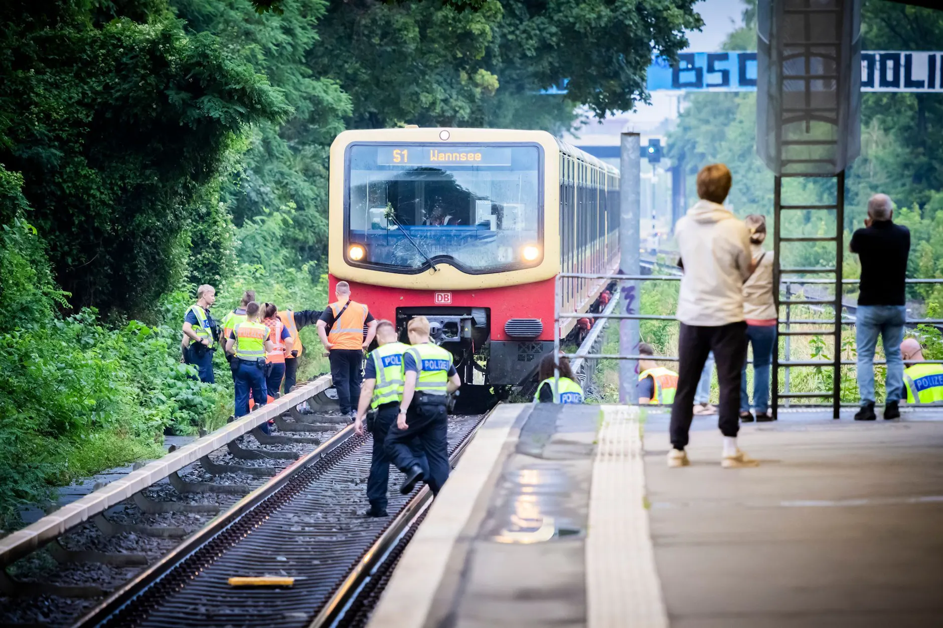 Einsatzkräfte stehen am S-Bahnhof Sundgauer Straße vor der verunglückten S-Bahn der Linie S1.