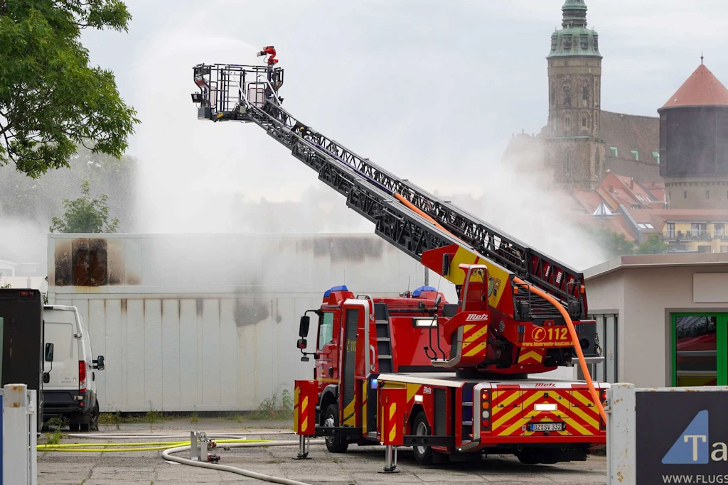 Die Feuerwehr löscht mit einer ferngesteuerten Spritze einen Brand in einem Batteriespeicher.