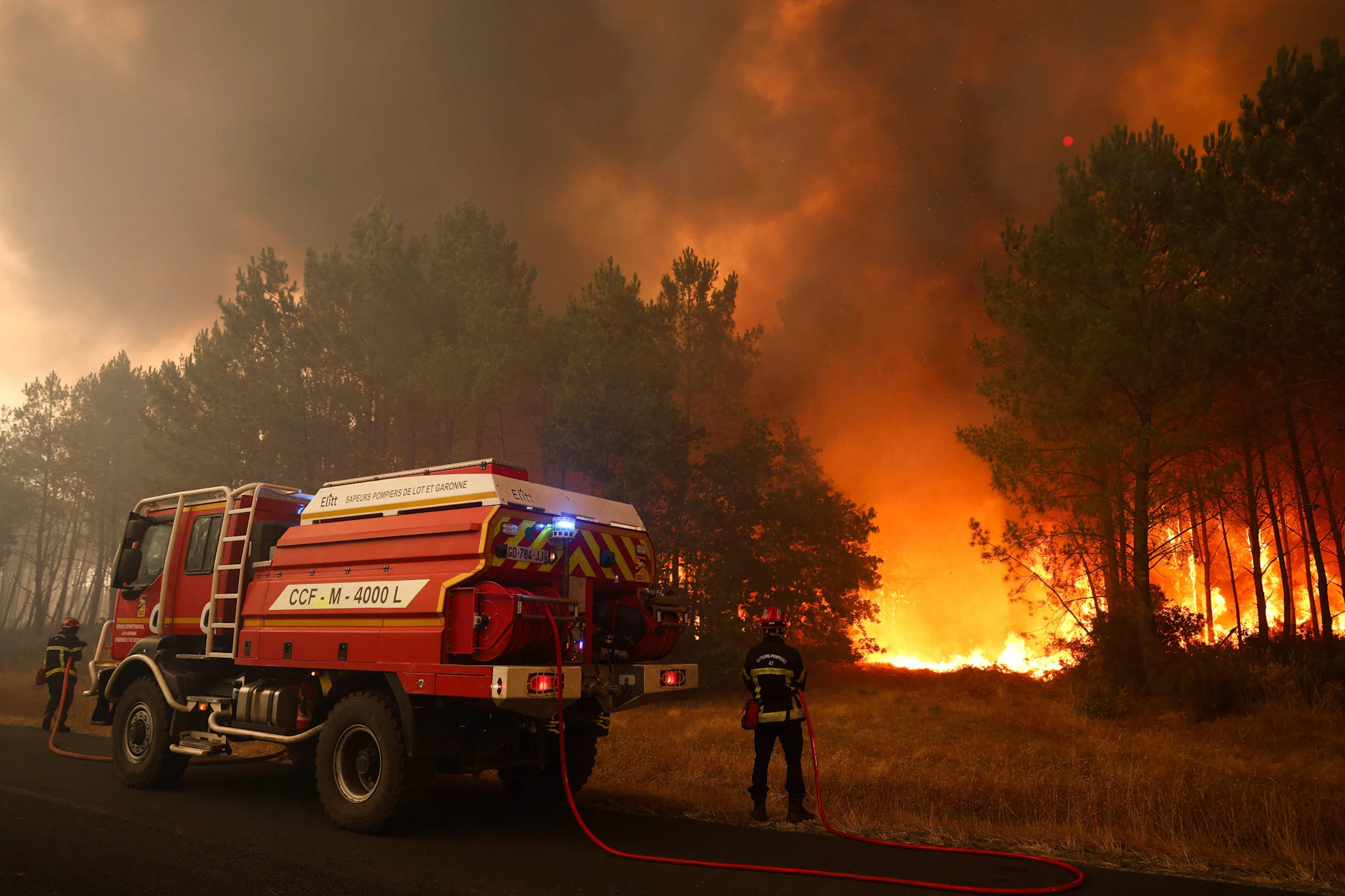 Feuerwehrleute versuchen in der Nähe von Le Porge im Südwesten Frankreichs mit einem Waldbrandlöschfahrzeug, die brennenden Bäume zu löschen.