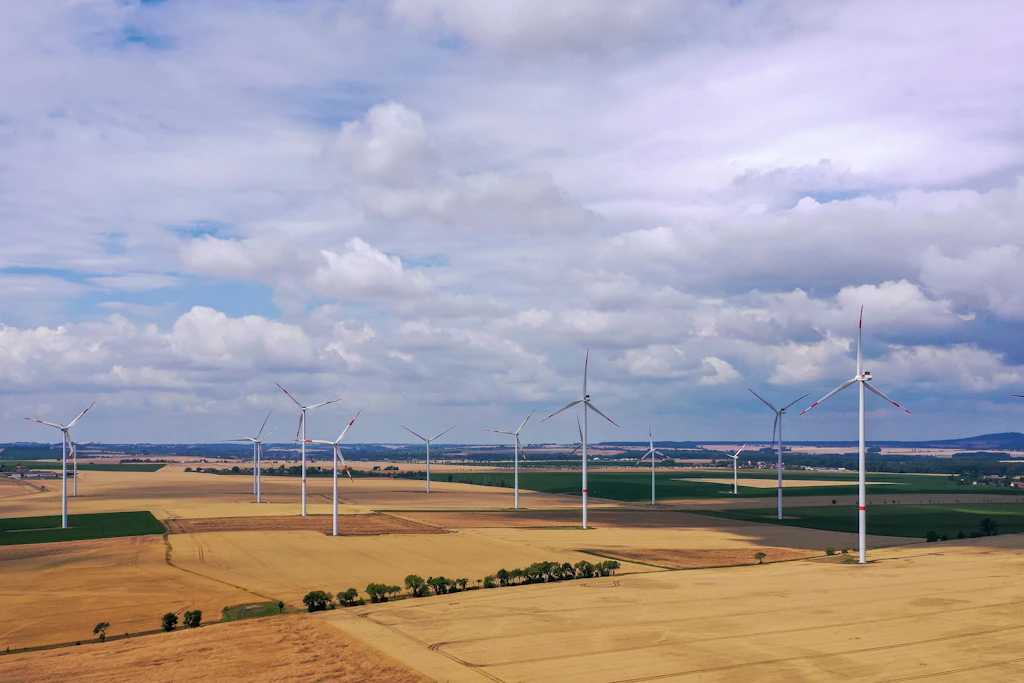 Windräder drehen sich hinter einer Hochspannungsleitung auf einem Feld bei Riesa. (Symbolbild)
