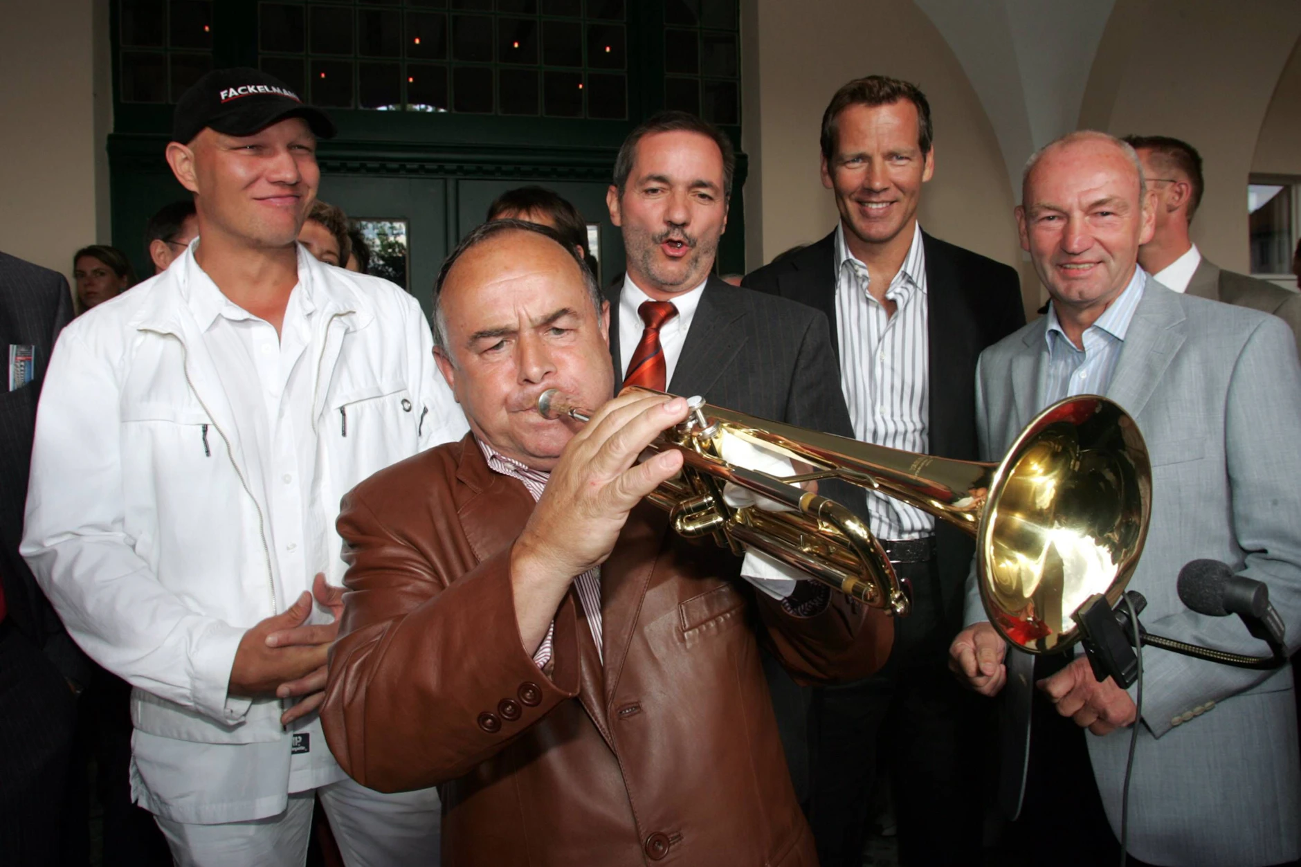 Wolfgang Behrendt spielt 2005 zur Eröffnung der Max-Schmeling-Ausstellung in Bad Saarow auf seiner Trompete. Box-Legenden wie Axel Schulz (l.) und Henry Maske (2.v.r.) sowie Trainer Manfred Wolke (r.) hören zu.