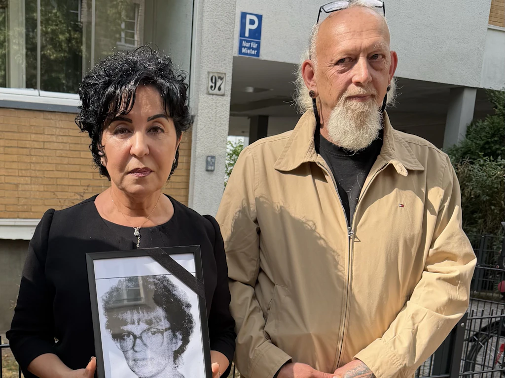 Bezirksbürgermeisterin Emine Demirbüken-Wegner mit einem Foto von Beate Fischer und Christian Axt, der die Bodenplatte gefertigt hat.