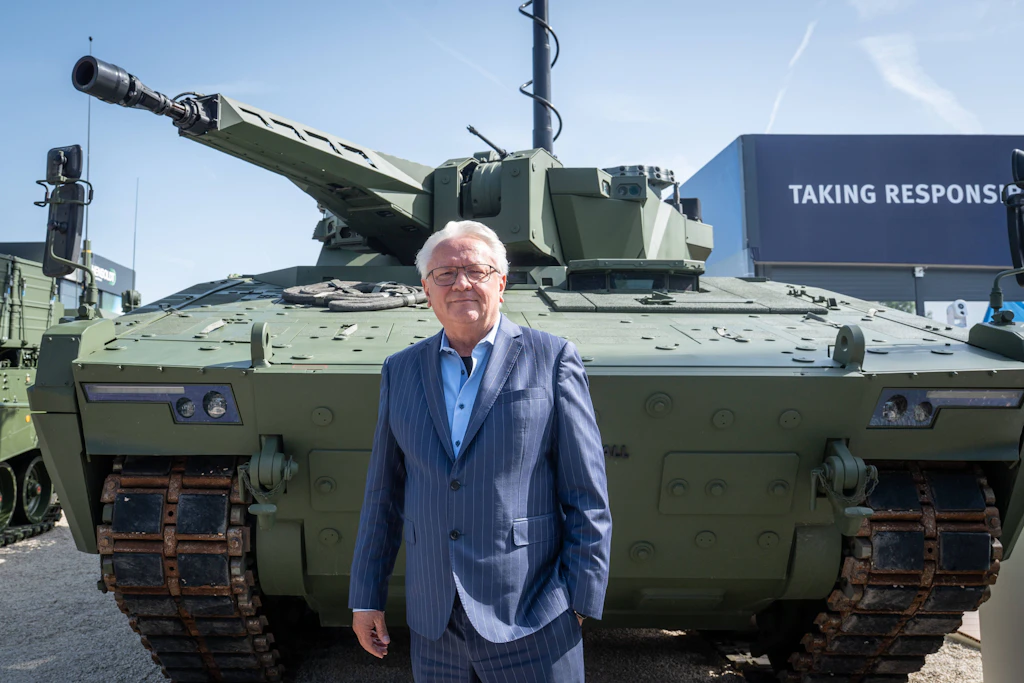 Rheinmetall-Chef Armin Papperger vor einem Schützenpanzer Lynx Recce auf einer Rüstungsmesse