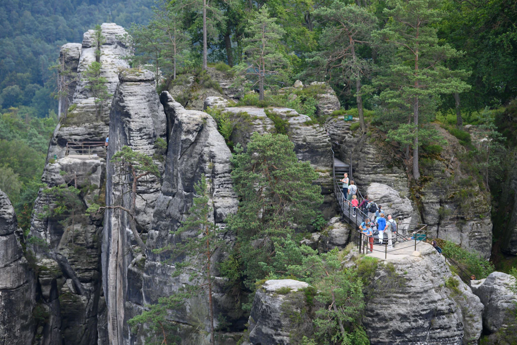 Touristen im Nationalpark Sächsische Schweiz auf einer Aussichtsplattform der Felsenburg Neurathen.