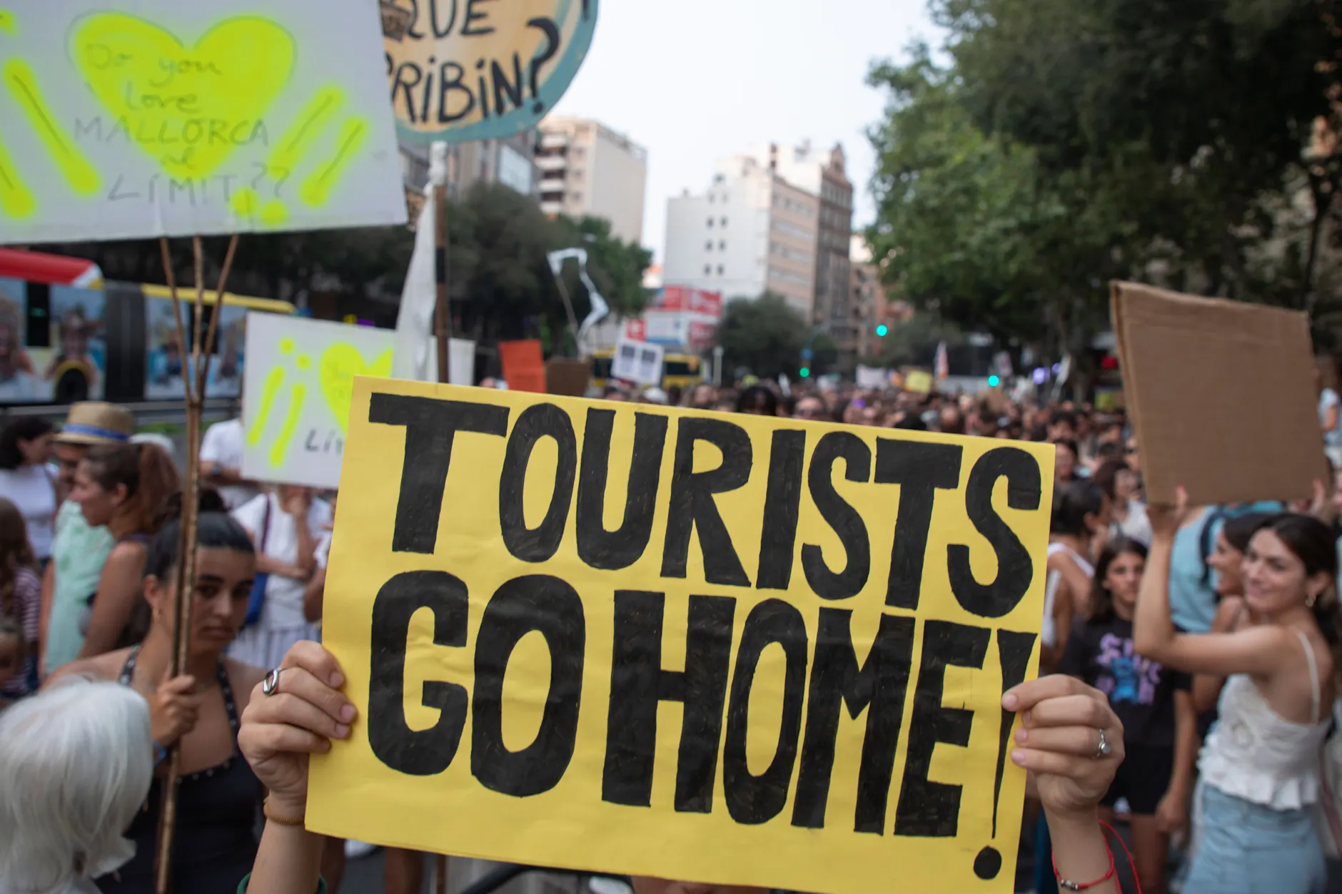 Ein Teilnehmer des Protestzugs in Palma gegen den Massentourismus auf Mallorca hält ein Schild mit der Aufschrift „Tourists go home“ während einer Demonstration gegen den Tourismus auf Mallorca.