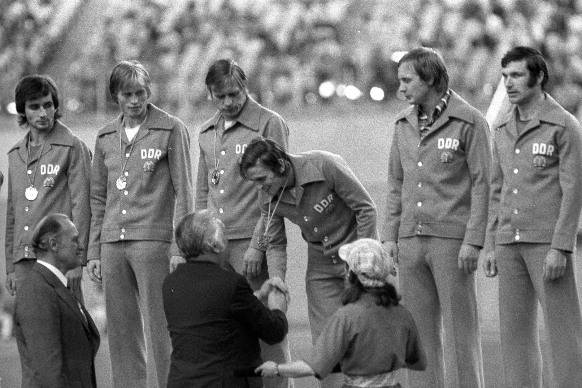 Am 31. Juli 1976 feiert die DDR Olympiagold in Montreal: (v.li.): Reinhard Häfner, Hans Jürgen Riediger, Bernd Bransch, Martin Hoffmann, Gerd Kische und Wolfram Löwe werden von FIFA-Präsident Joao Havelange (vorn li., Brasilien) und IOC-Präsident Lord Michael Killanin (Irland) geehrt.