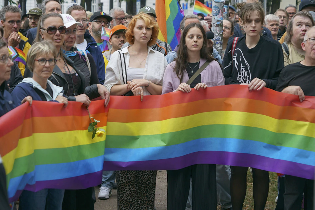 Schweigen hinter der Regenbogenfahne: In Berlin gedenken Menschen der Opfer des Anschlags beim Christopher Street Day. Eine Frau starb, 29 weitere Menschen wurden verletzt.