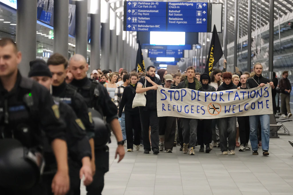 Teilnehmer einer linken Demonstration gehen mit einem Transparent durch das Terminal des Flughafens Leipzig-Halle. Sie protestieren gegen einen mutmaßlichen Abschiebeflug nach Afghanistan.