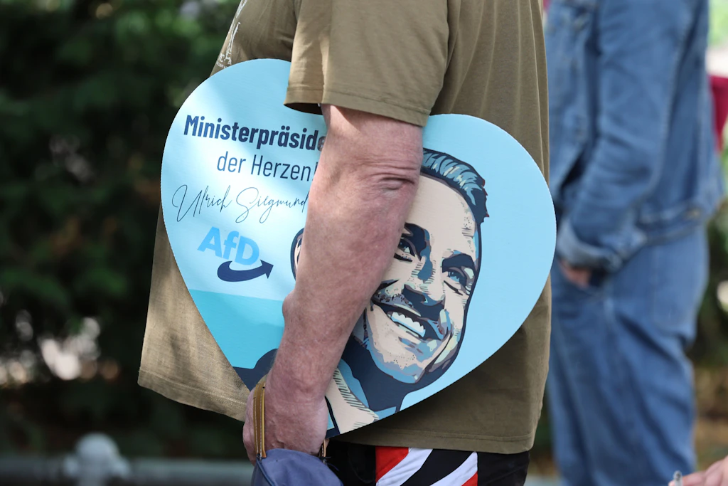 Ein Mann steht mit einem Herz mit einer Wahlwerbung von AfD-Spitzenkandidat Siegmund für ein Autogramm an.