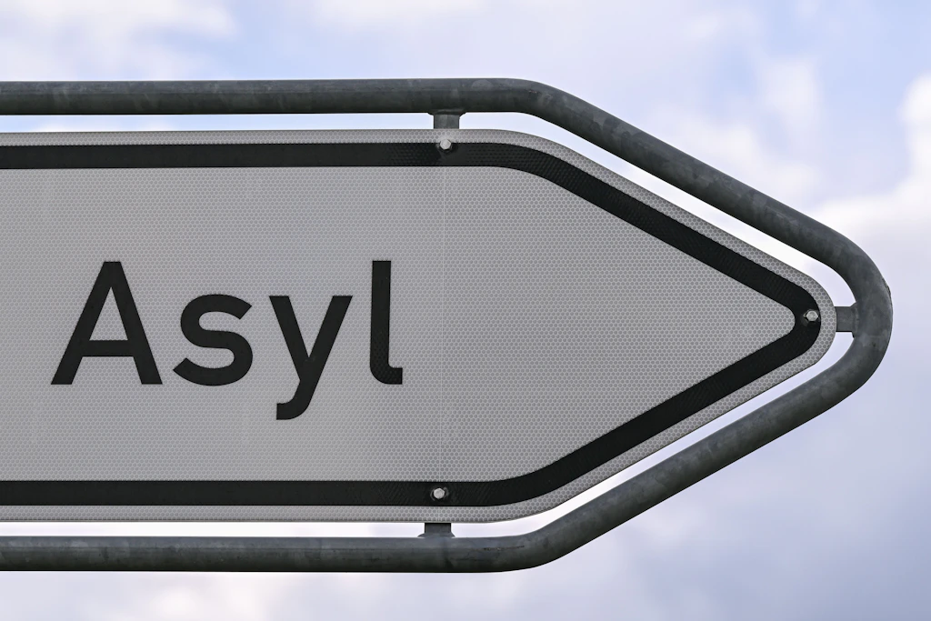 Das Wort „Asyl“ steht auf einem Wegweiser zur Erstaufnahme-Einrichtung (EAE) des Landes Brandenburg in Eisenhüttenstadt.