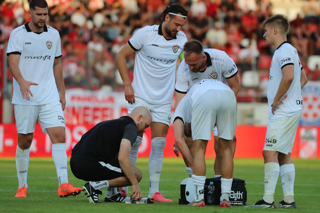 BFC-Physio Elias Ulsamer kümmert sich auf dem Platz um den Fuß von Rufat Dadashov.