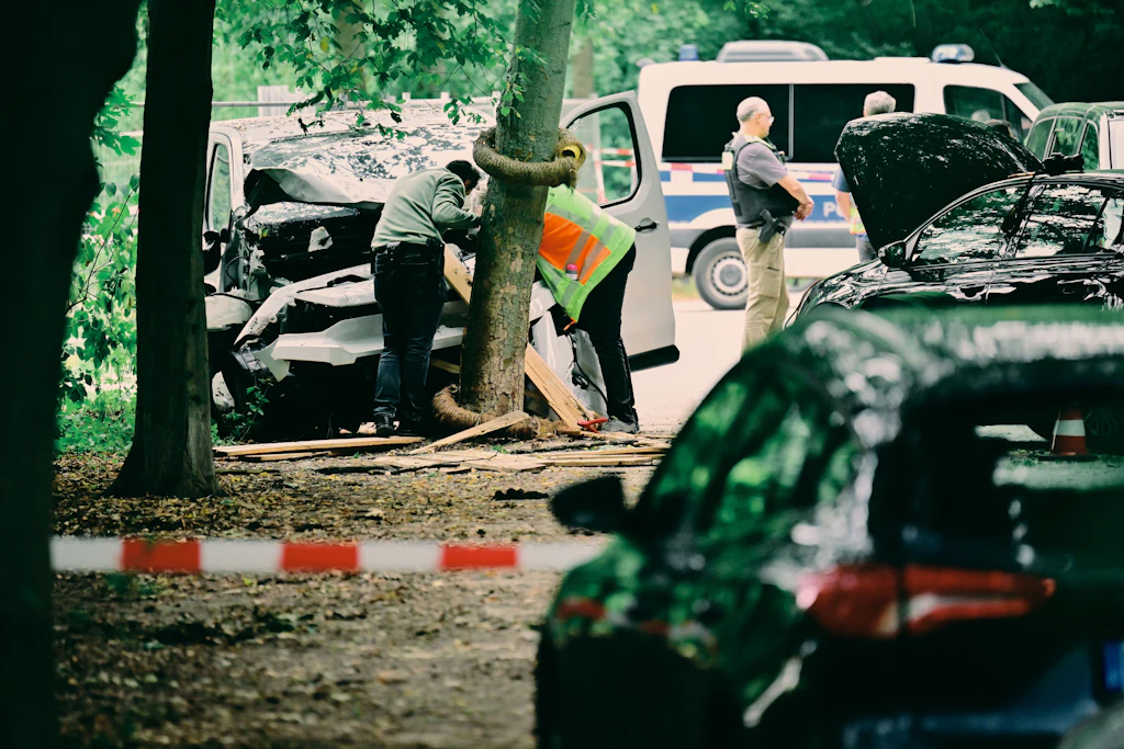 Mitarbeiter der Unfallforschung betrachtet ein Fahrzeug, das in einem Baum im Bereich des Tiergartens gefahren ist. Am Rande des Christopher Street Day in Berlin war das Fahrzeug in eine Menschenmenge gefahren. Dabei wurde eine Frau getötet, weitere Menschen wurden zum Teil schwer verletzt.